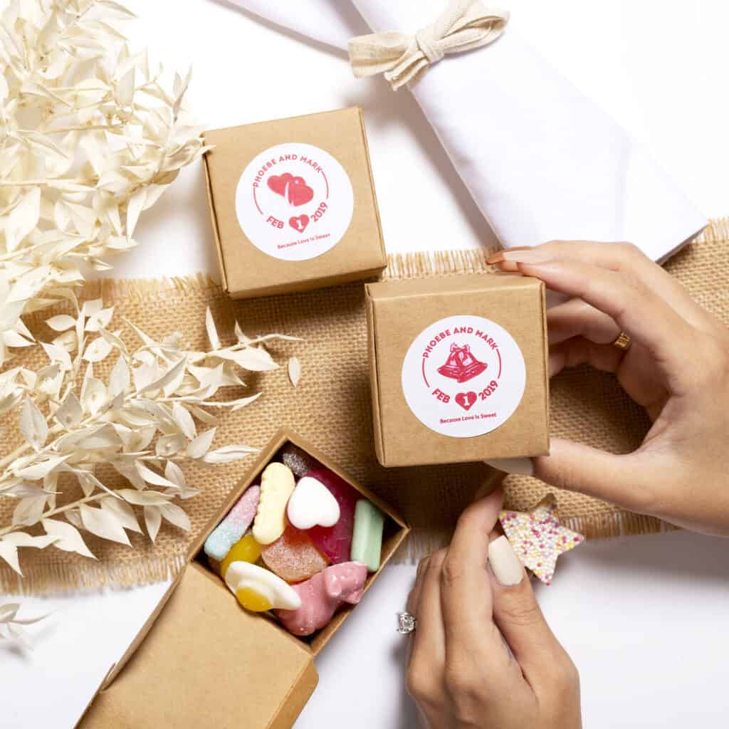 Little wedding fvour boxes with pick n mix sweets inside being held by two hands